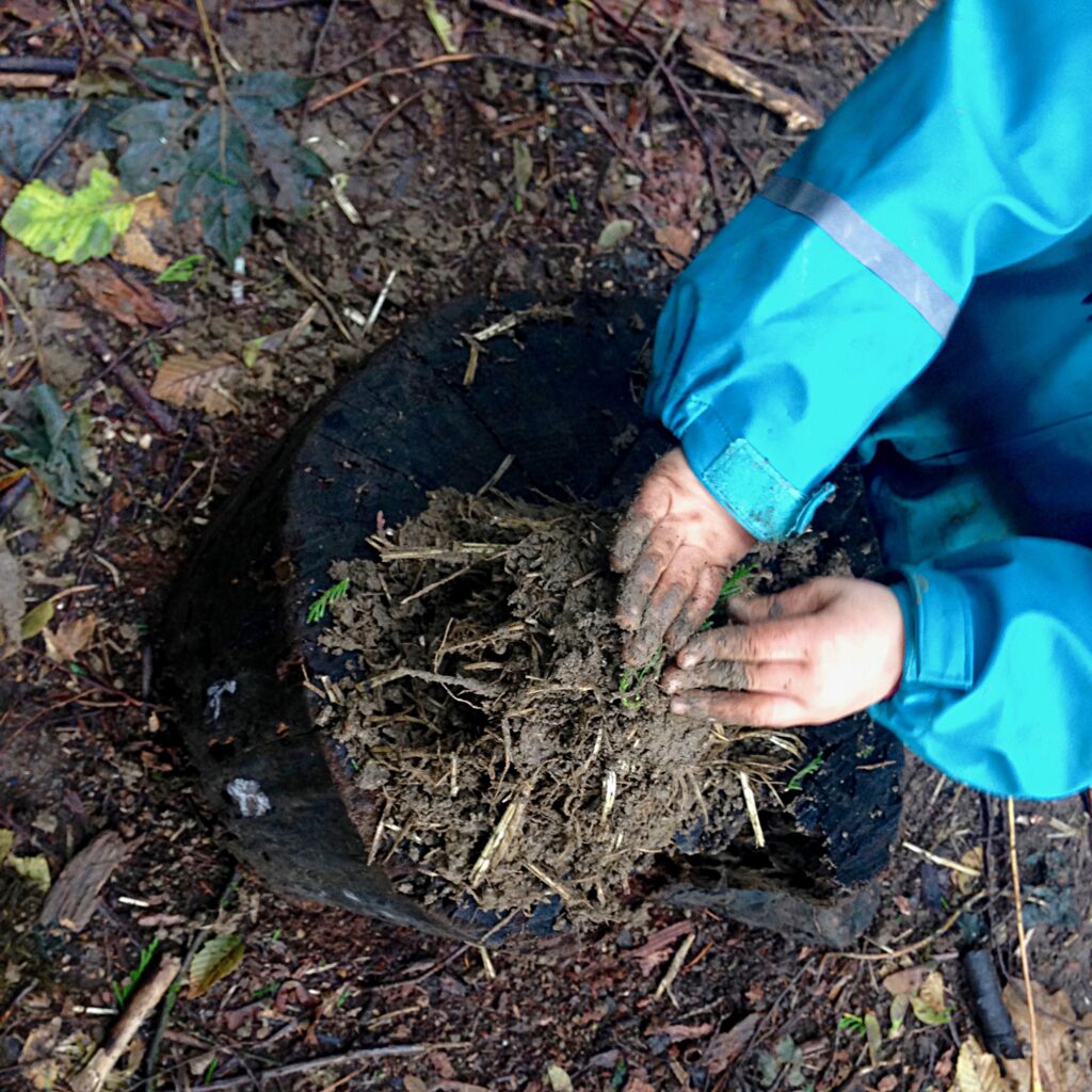 Playing in the mud at our outdoor forest nature preschool